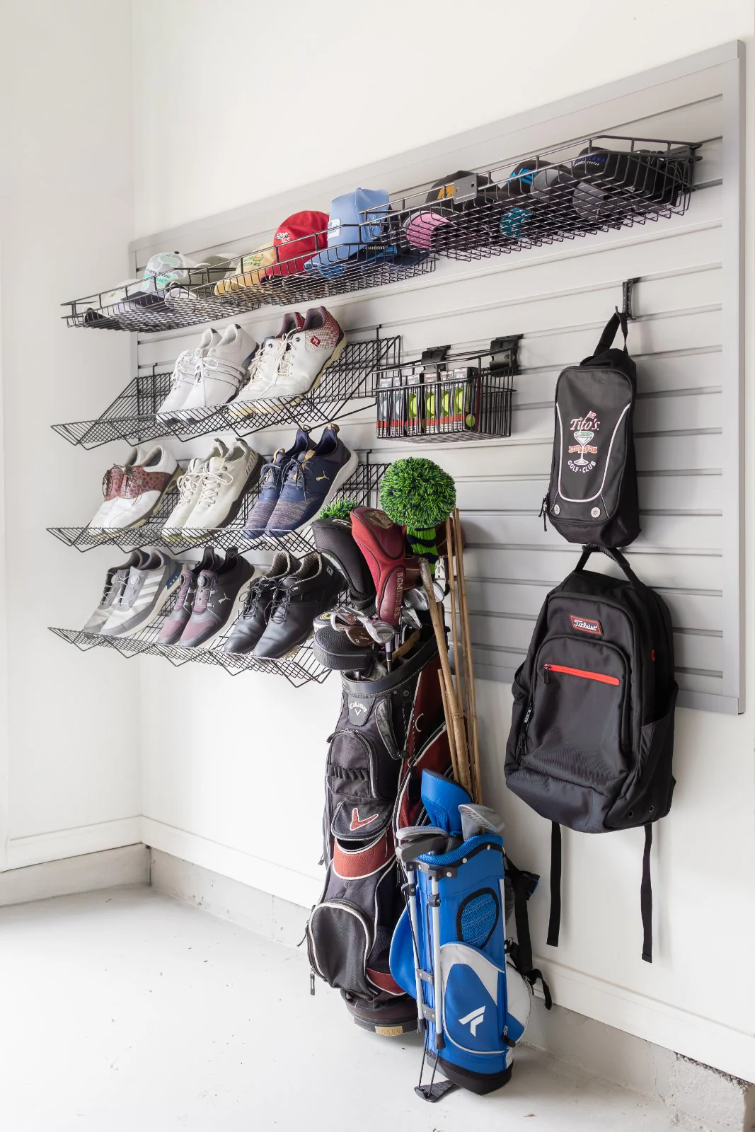 A garage sports wall, rackets and gear hung and sorted