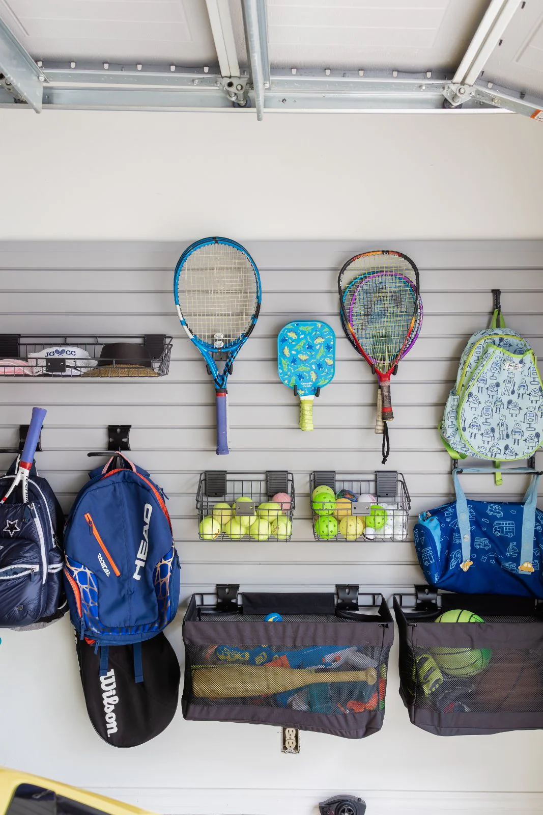 A garage golf wall, shoes and bags stored on rails